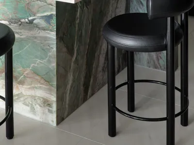 Modern interior with marble counter and black bar stools.