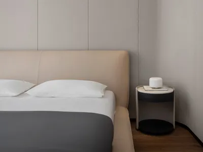 A modern bedroom with neutral-toned materials and a minimalist design.