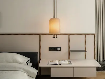 Minimalist bedroom with modern white furniture and pendant light fixture.