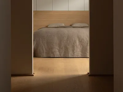 A minimalist bedroom with natural wood and light-colored textiles, showcasing a serene and simple design.