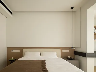 A minimalist bedroom with a bed, nightstands, and a hanging light fixture.