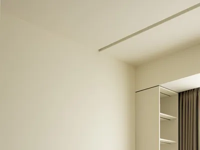 Minimalist bedroom with wooden furniture and white bedding.