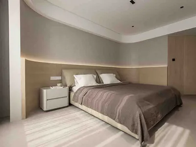 A modern bedroom with neutral-toned furniture and a minimalist design.