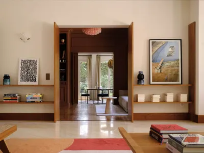 An industrial-style living room with wooden shelves and a view of a dining area.