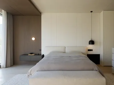 簡約臥室內有紋理牆板與現代床具，搭配懸吊燈具及懸浮式床頭櫃。