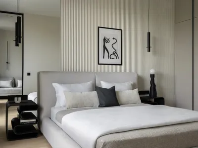 A minimalist bedroom with a bed made of fabric and metal, surrounded by wooden flooring.