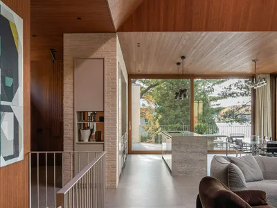 現代客廳與廚房，搭配混凝土地板以及木質牆面與天花板。