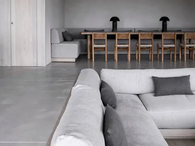極簡客廳採用混凝土地板與家具，配有混凝土L型沙發及木製餐桌