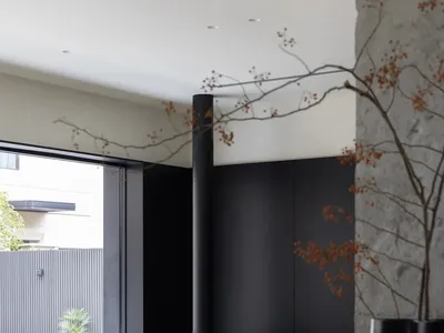 A minimalist living room with concrete walls and a modern fireplace.