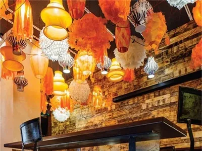 An industrial-themed restaurant interior with metal, wood, concrete, and fabric elements.