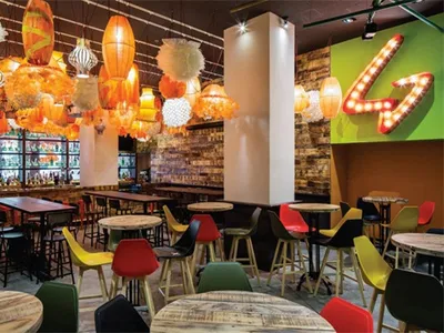 Industrial-style restaurant featuring wood, metal, and plastic furniture and decor elements.