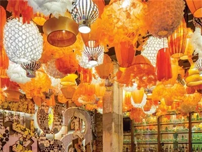 A brightly lit interior of a modern restaurant with hanging fabric decorations and glass and metal elements.