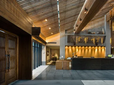 A hotel reception lobby featuring wooden architectural elements and design.