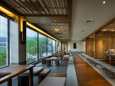 A modern restaurant interior featuring bamboo and concrete materials.