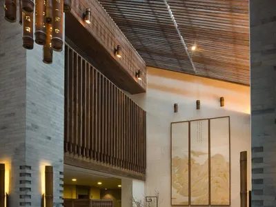 現代酒店大廳，混凝土地板、木質牆面與大理石點綴。