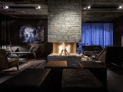 A modern industrial living room featuring a stone fireplace