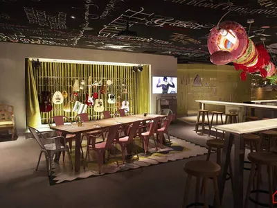 Industrial-style restaurant and bar interior with metal tables, wooden chairs, and glass chandeliers.