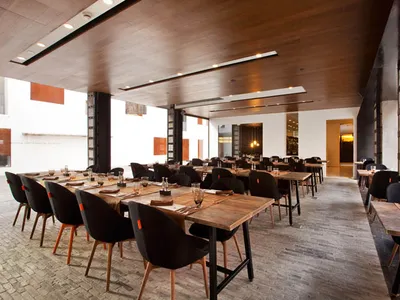 Industrial-style restaurant interior with wood accents, concrete finishes, and steel furniture.