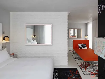 A minimalist hotel room featuring a white brick wall, concrete floor, and a red lounge chair.
