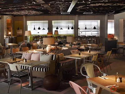 A modern restaurant interior with metallic furniture and colorful cushions, featuring large windows and a black ceiling with
