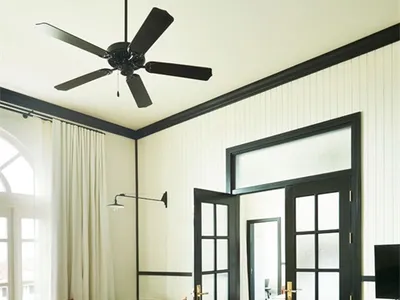 A stylish, industrial-themed living room with wooden flooring, black-framed windows, and a minimalistic design.