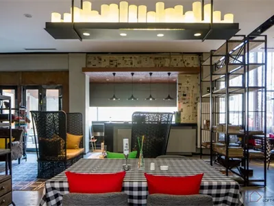 Restaurant interior with industrial design elements, featuring exposed concrete walls, metal accents, and wooden furniture.