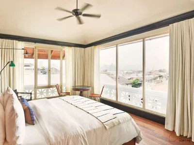 A modern, minimalist bedroom featuring a large window overlooking a cityscape.