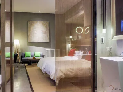 Modern minimalist bedroom featuring wood furniture, concrete walls, and fabric bedding.
