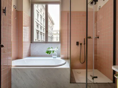 Modern bathroom with coral-colored ceramic tiles and a white marble countertop.