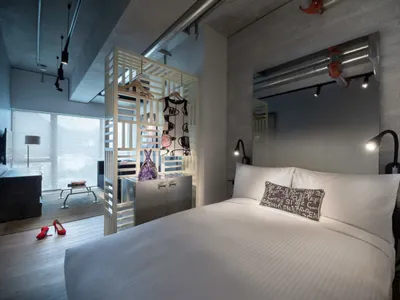 Photograph of a modern bedroom with concrete and wooden materials.