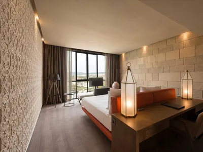 Modern hotel suite with wooden accents, concrete walls, and fabric furnishings.