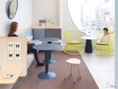 A modern restaurant interior with circular windows, colorful pendant lights, and contemporary furniture.