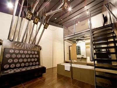 A hotel suite with an industrial design featuring metal and glass elements.