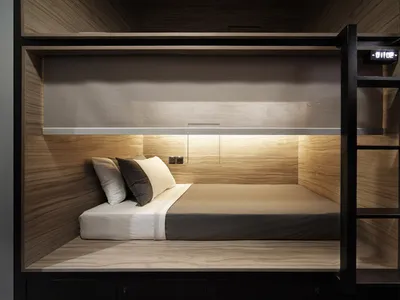 A minimalist bedroom with a wooden platform bed, white bedding, and black and white pillows.