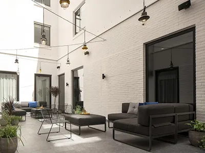 Industrial outdoor lounge area with concrete flooring and seating.