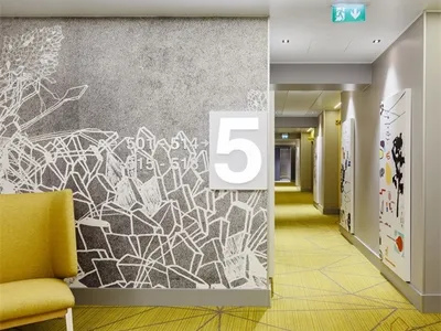 A minimalist hotel corridor with abstract artwork on the walls