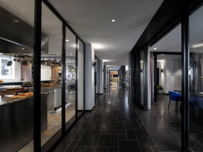 A modern restaurant corridor featuring glass walls.