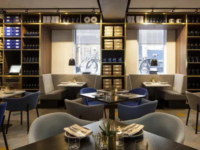 Modern restaurant interior with glass shelves, comfortable seating, and stylish decor.