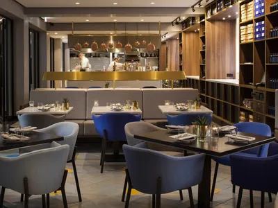 A modern restaurant interior with neutral tones and contemporary furniture.