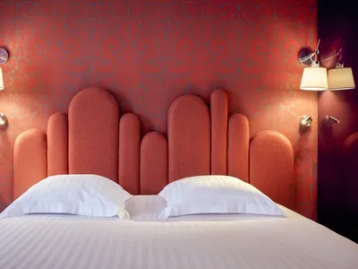 Modern bedroom with an orange upholstered headboard and white bedding.