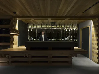 Modern hotel reception area with a wooden desk and lighting.
