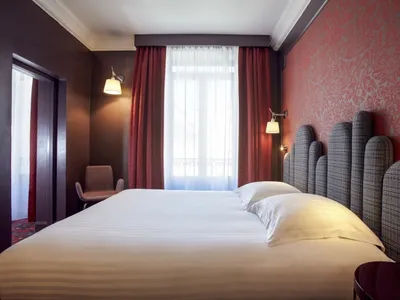 整潔的床鋪搭配白色床單，以及紅色圖紋窗簾的飯店臥室場景。