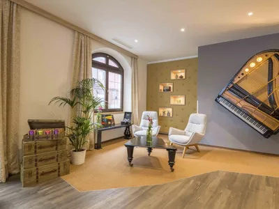 A living room with industrial design elements, featuring wooden furniture, fabric seating, and metal accents.
