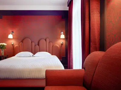 Modern bedroom with bright red fabric headboard and curtains.