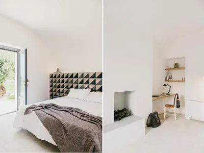 A minimalist bedroom with a bed, blanket, and a fireplace with shelves and a desk.