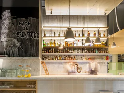 Modern bar interior with concrete walls, wooden accents, and glass countertops