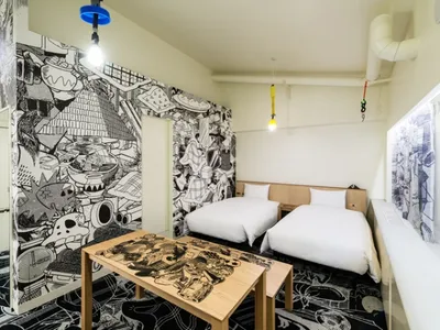 Modern hotel room with twin beds and colorful, abstract mural walls