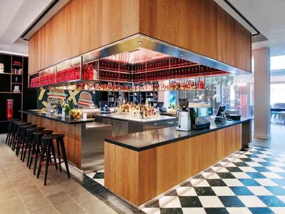 Modern restaurant bar with wooden paneled walls and black countertops