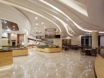 Modern restaurant interior with marble flooring and walls, featuring contemporary design elements.