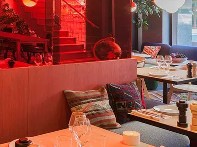 Modern industrial restaurant interior with glass, steel, and wooden accents.